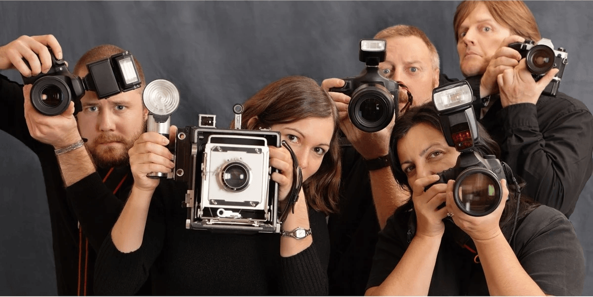 Grupo de fotógrafos segurando câmaras diferentes