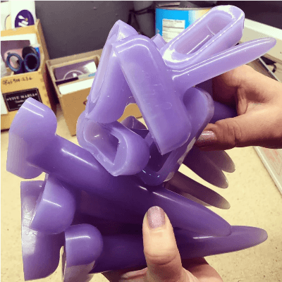 Two hands holding a pile of  Sh! silicone dilators