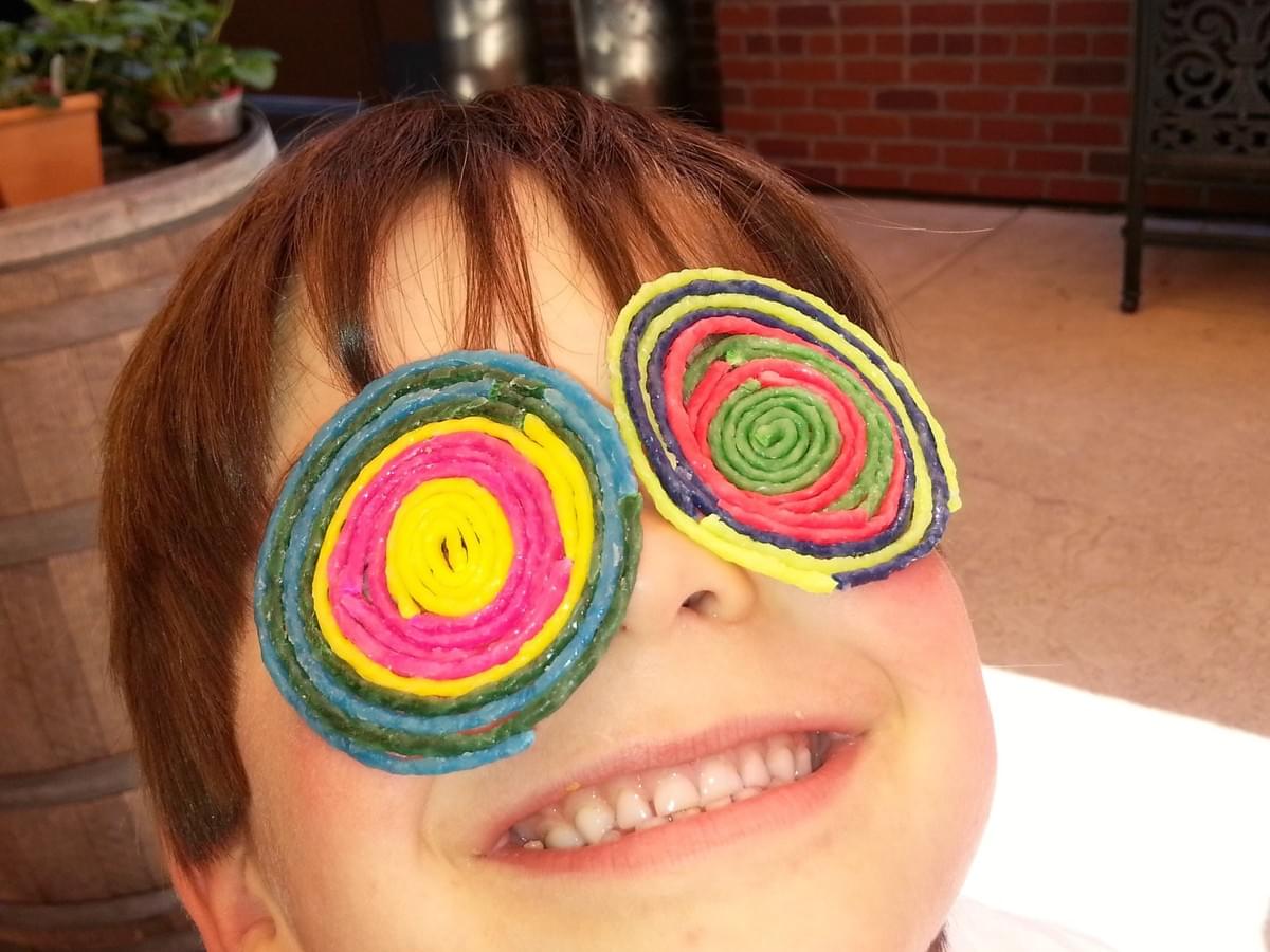 A child with funny glasses made with wax art materials. Photo is not a client. Photo credit: Laurie Ferguson. 