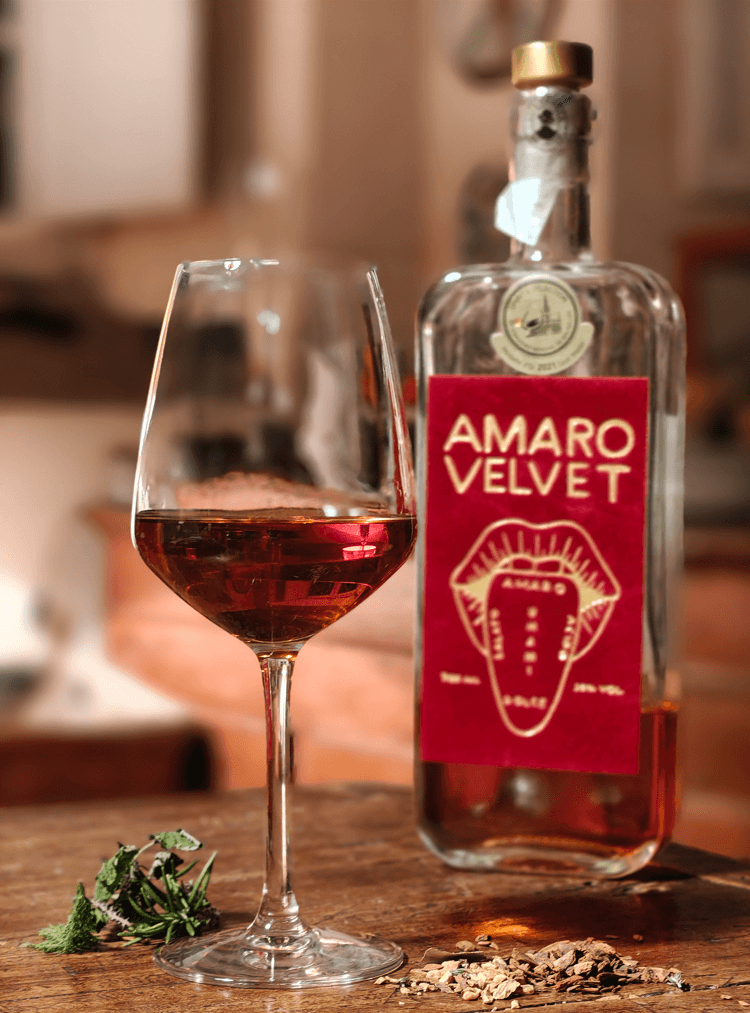 amaro digestivo artigianale servito in calice a temperatura ambiente