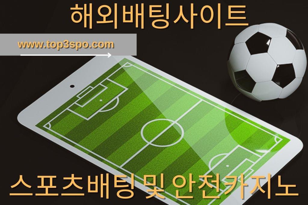 white mobile phone with soccer field wallpaper and soccer ball in black background.