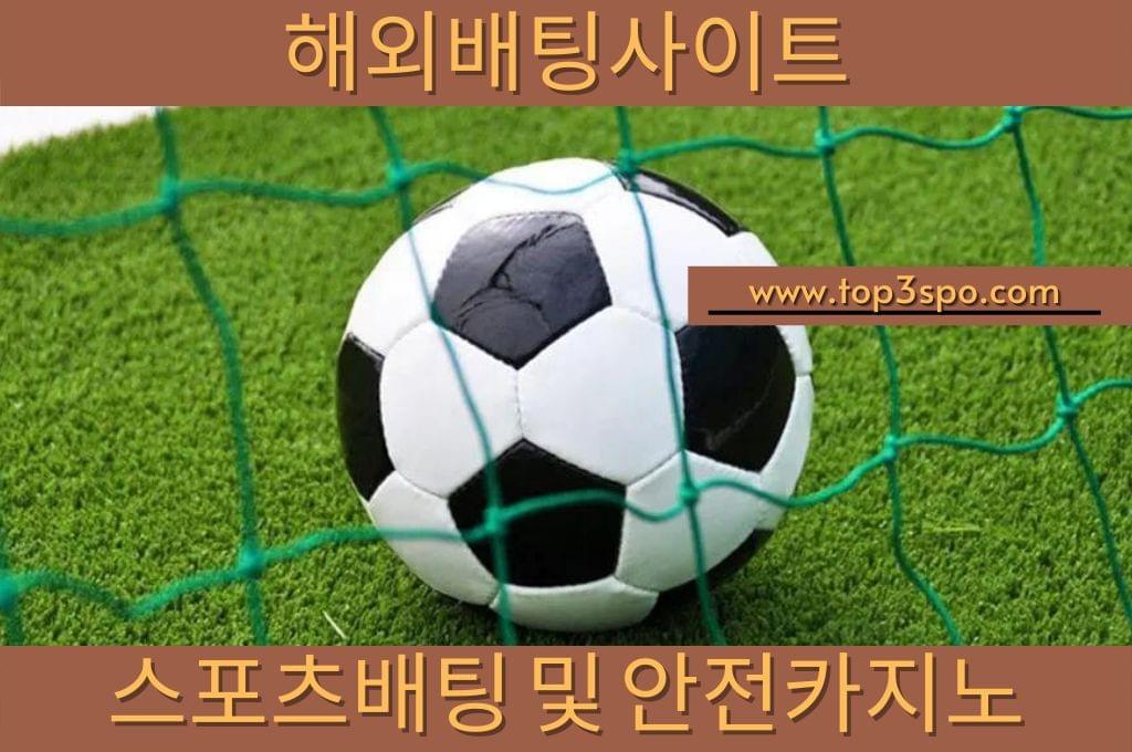 Soccer ball under the green goal net.