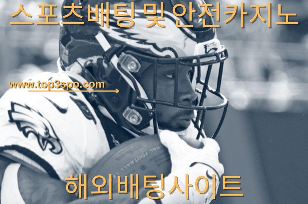 Black and white football player holding the ball.