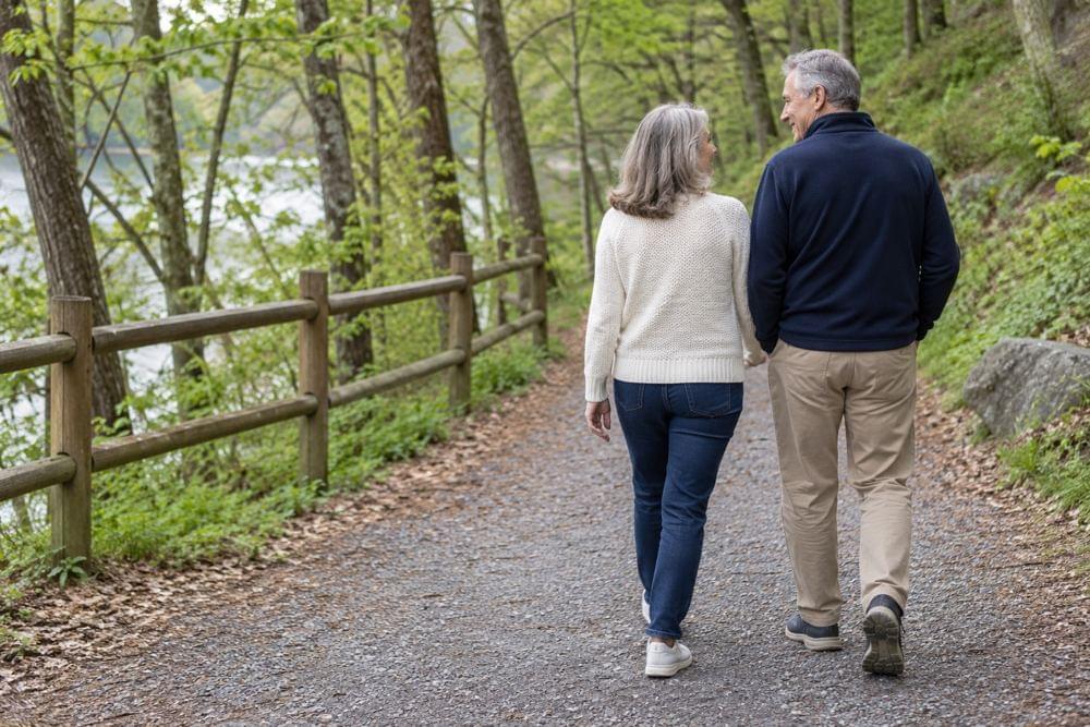 A couple walking together along a wooded path