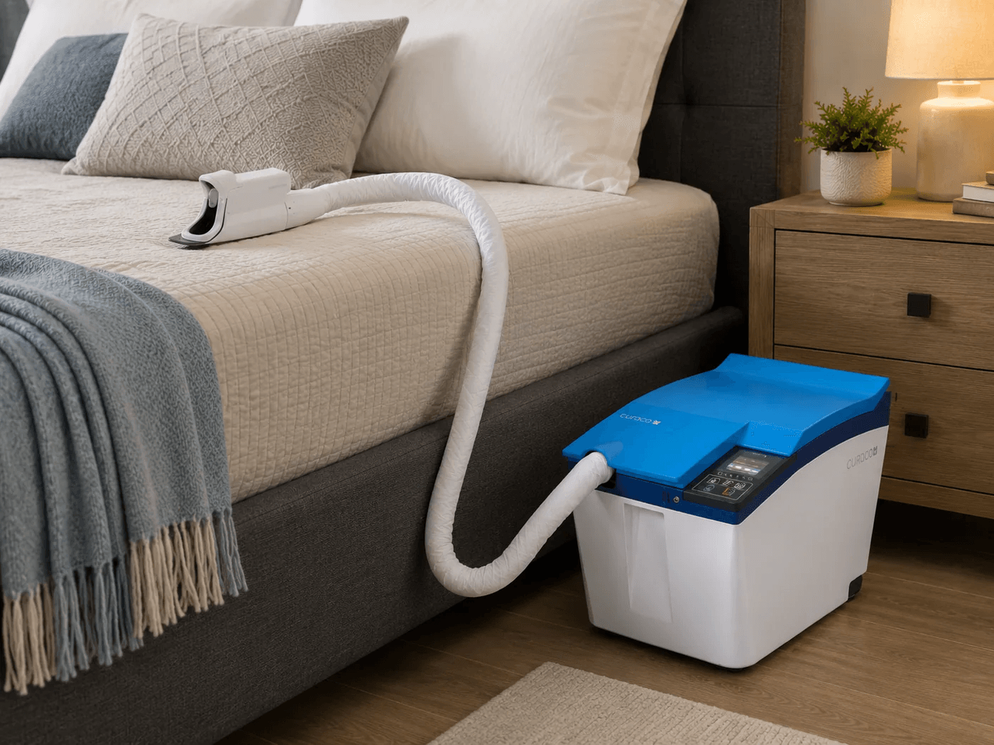 Carebidet positioned beside a bed with the interface resting on the mattress