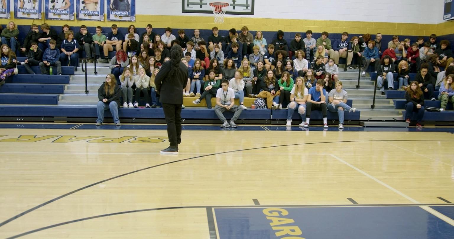 Maurice F. Martin speaking to middle school students in a school gymnasium