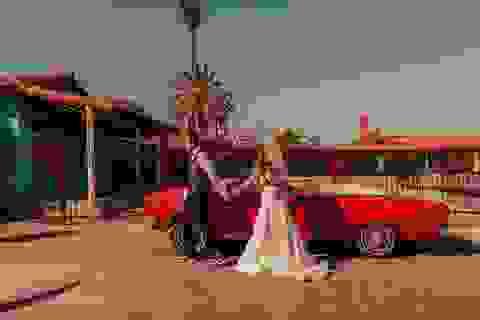 Las Vegas elopement photo of couple in wedding attire posing with red vintage car on downtown streets Las Vegas elopement photo of couple in wedding attire posing with red vintage car on downtown streets