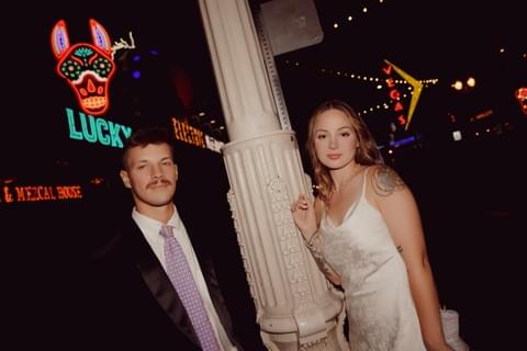 Elopement photo of couple on Fremont Street in Las Vegas at night time with neon lights and flash