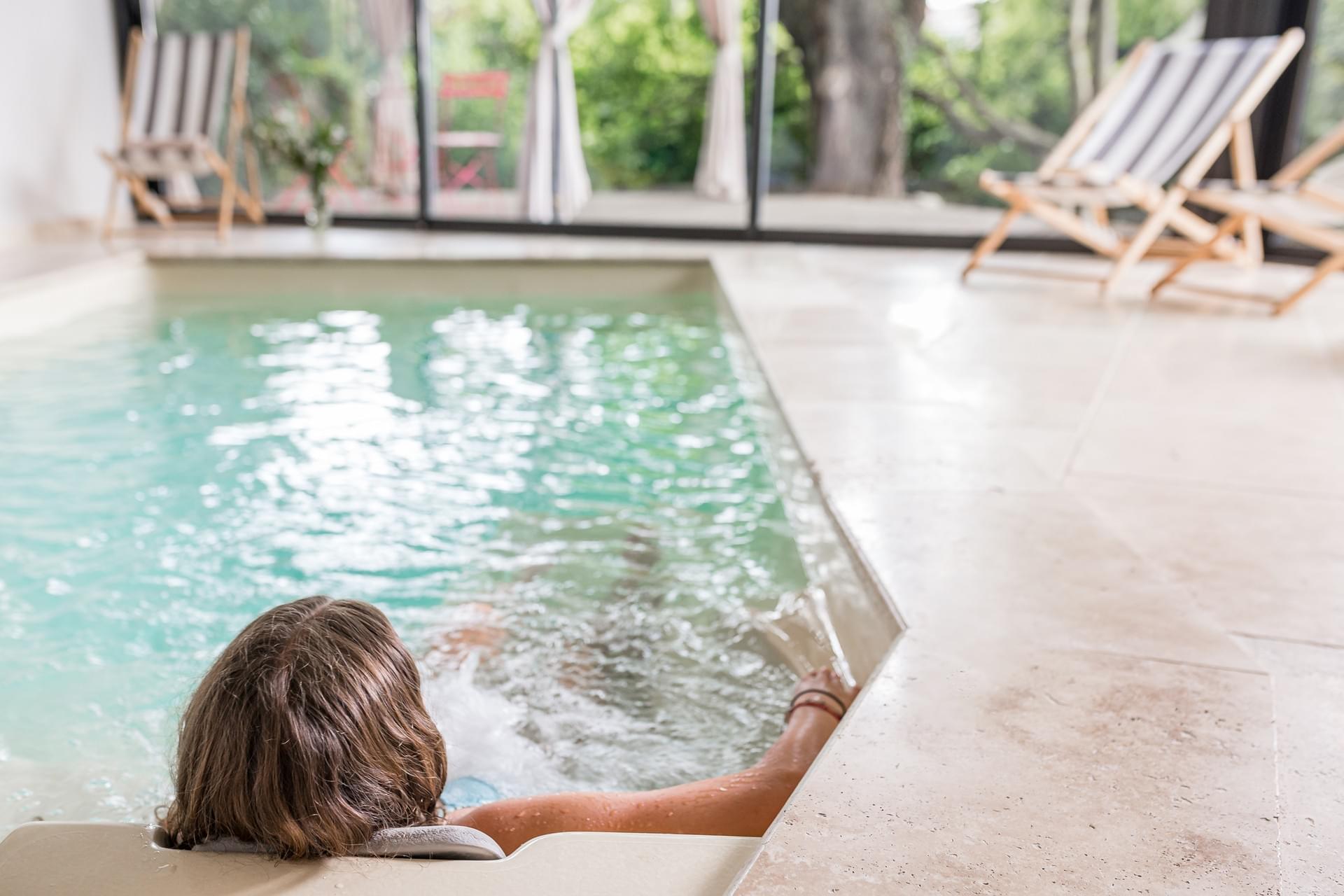 Espace bien-être privatif de la Villa Elisa M : spa de nage, transats et sauna